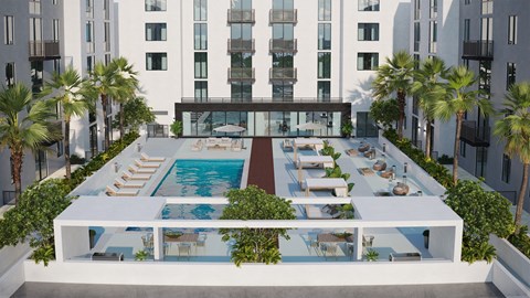 A pool surrounded by palm trees and loungers.