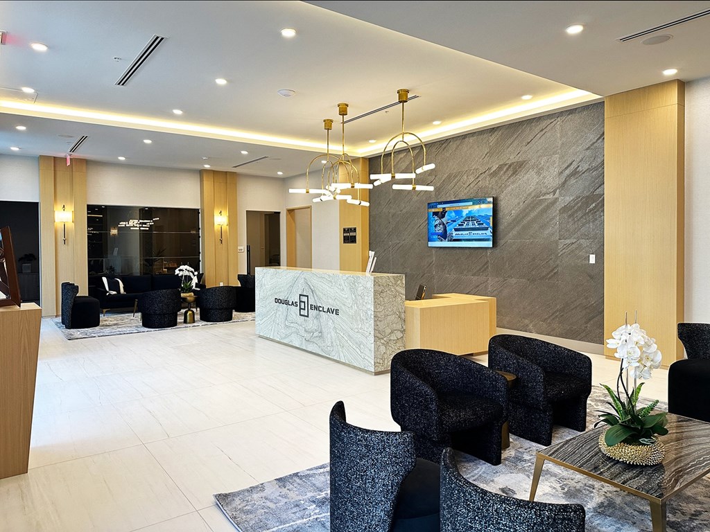 a modern hotel lobby with a reception desk and chairs  at Douglas Enclave, Miami