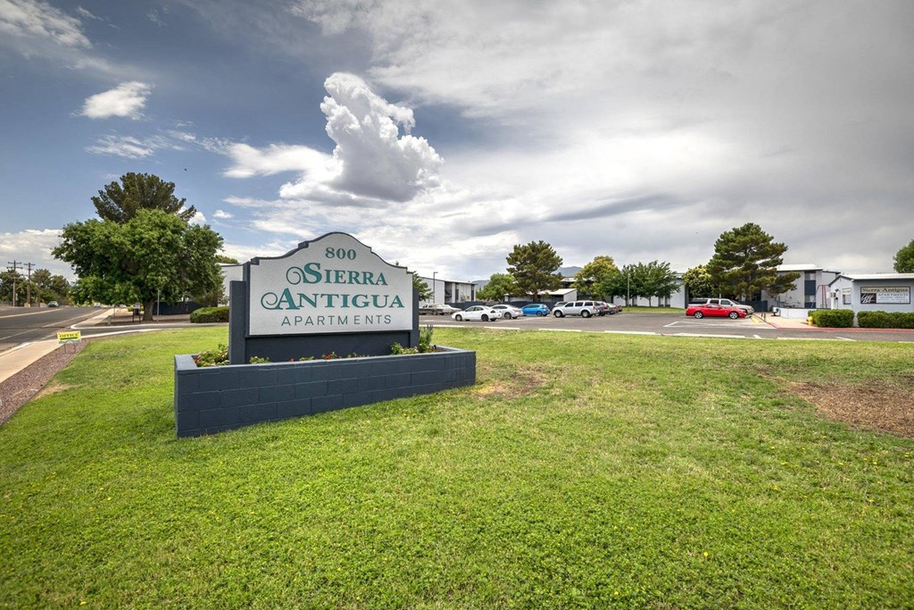 a large sign with the name of the apartment complex in front of it