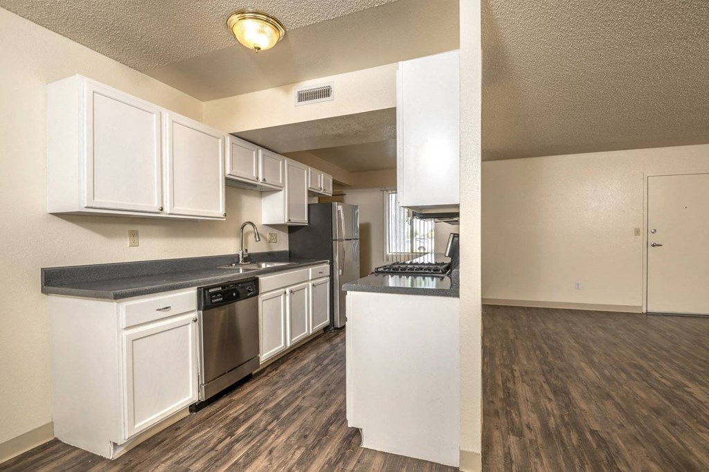 a kitchen with white cabinets and black countertops