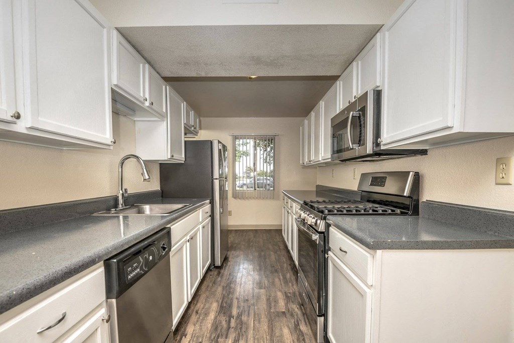 a kitchen with white cabinets and stainless steel appliances