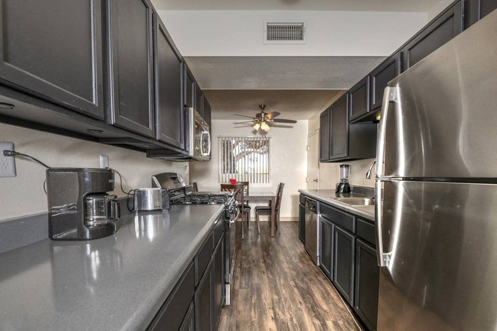 a kitchen with black cabinets and stainless steel appliances