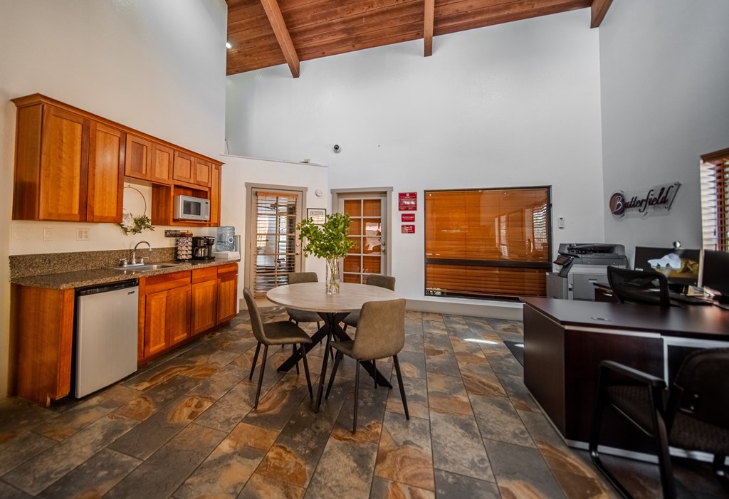 A kitchen with wooden cabinets and a stone floor.