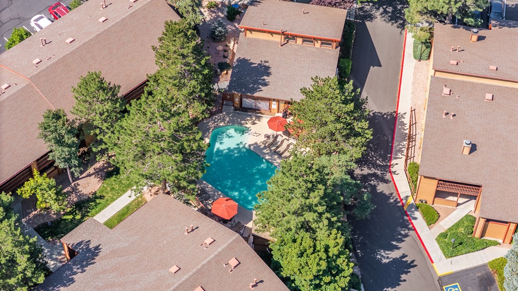 A bird's eye view of a neighborhood with houses and a pool.