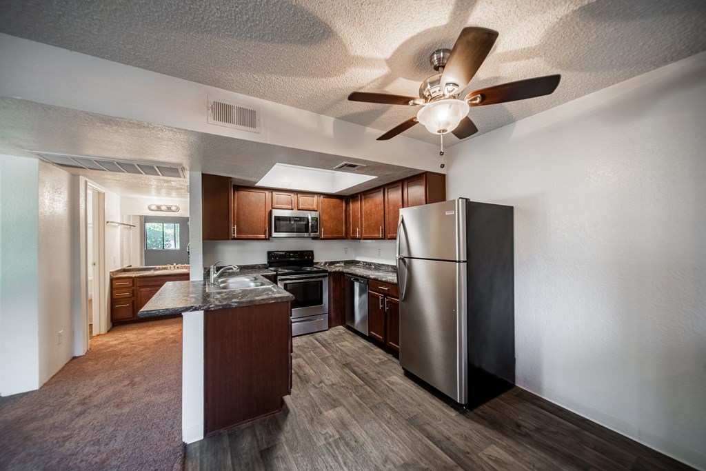 A kitchen with a refrigerator, stove, and oven.