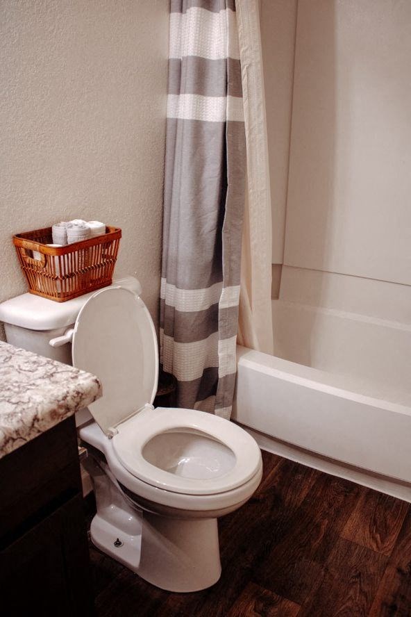 a white toilet sitting next to a bath tub