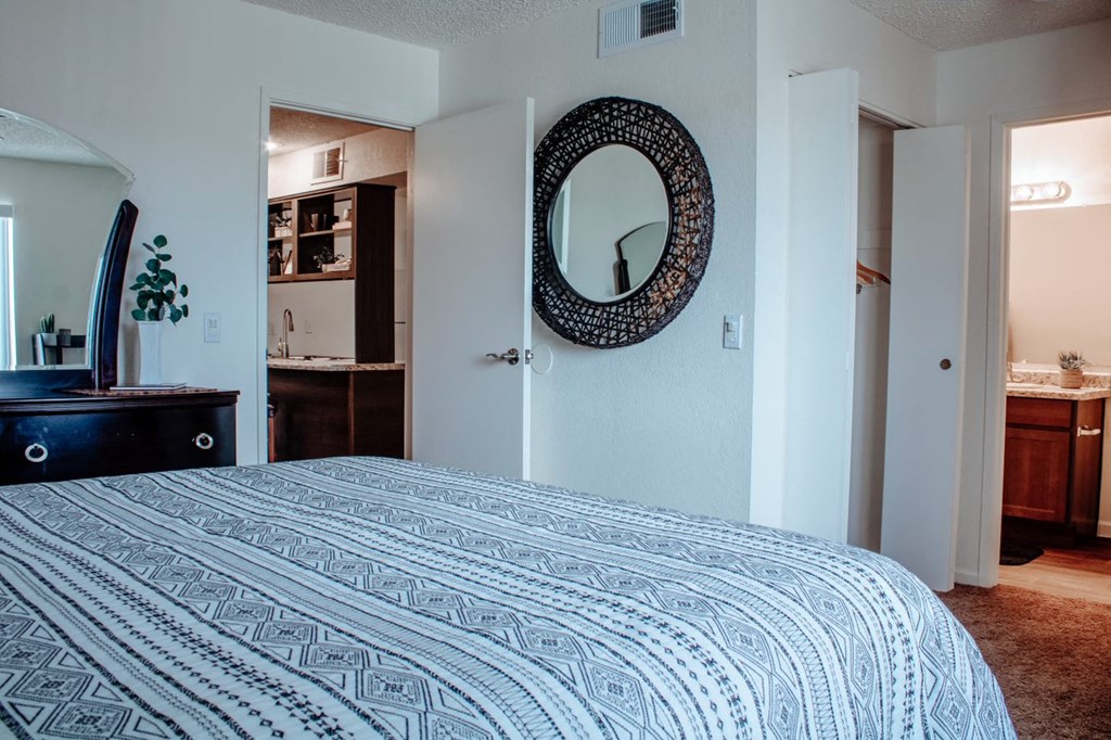 a bedroom with a large bed and a mirror