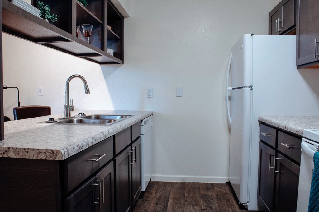 a kitchen with dark cabinets and a white refrigerator