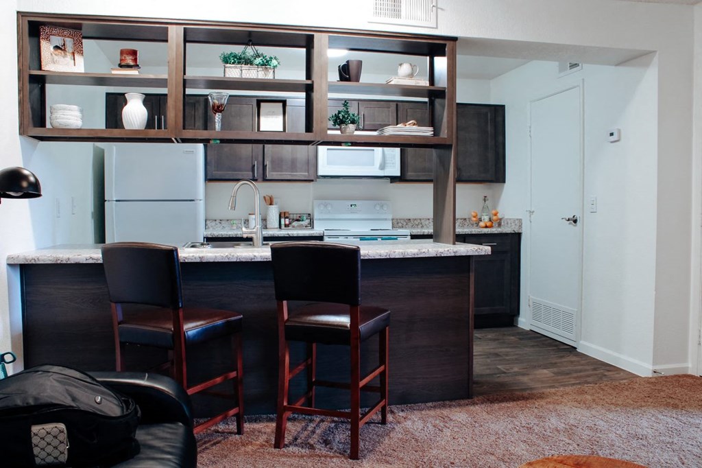 a kitchen with an island and three stools in front of it