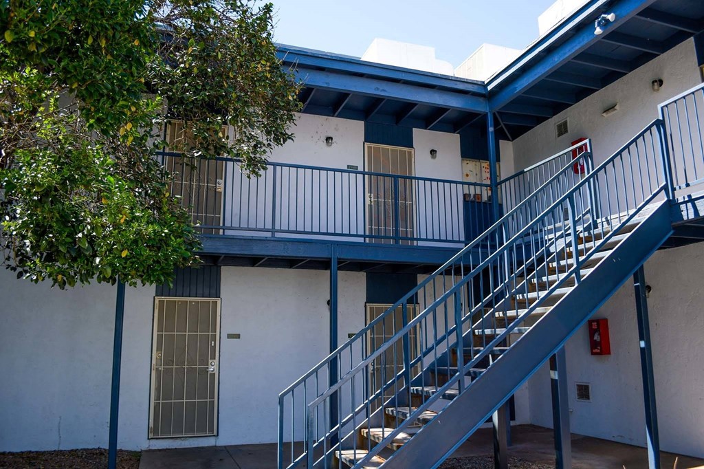 a picture of a building with stairs and a tree in front of it