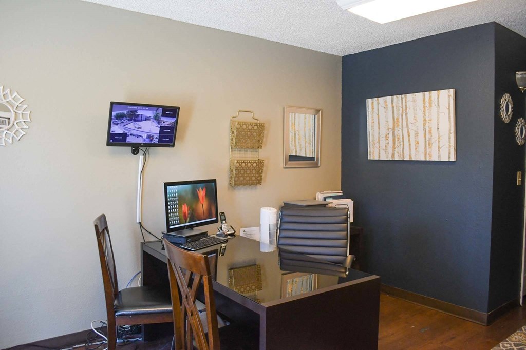 a desk with a computer and a monitor in a room