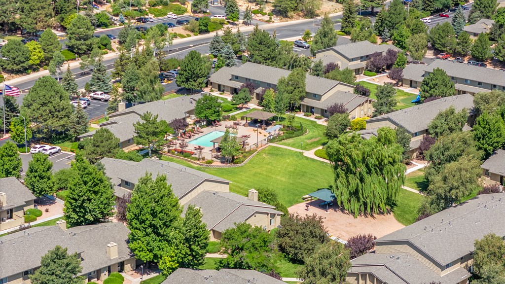 A bird's eye view of a residential neighborhood with houses and a swimming pool.