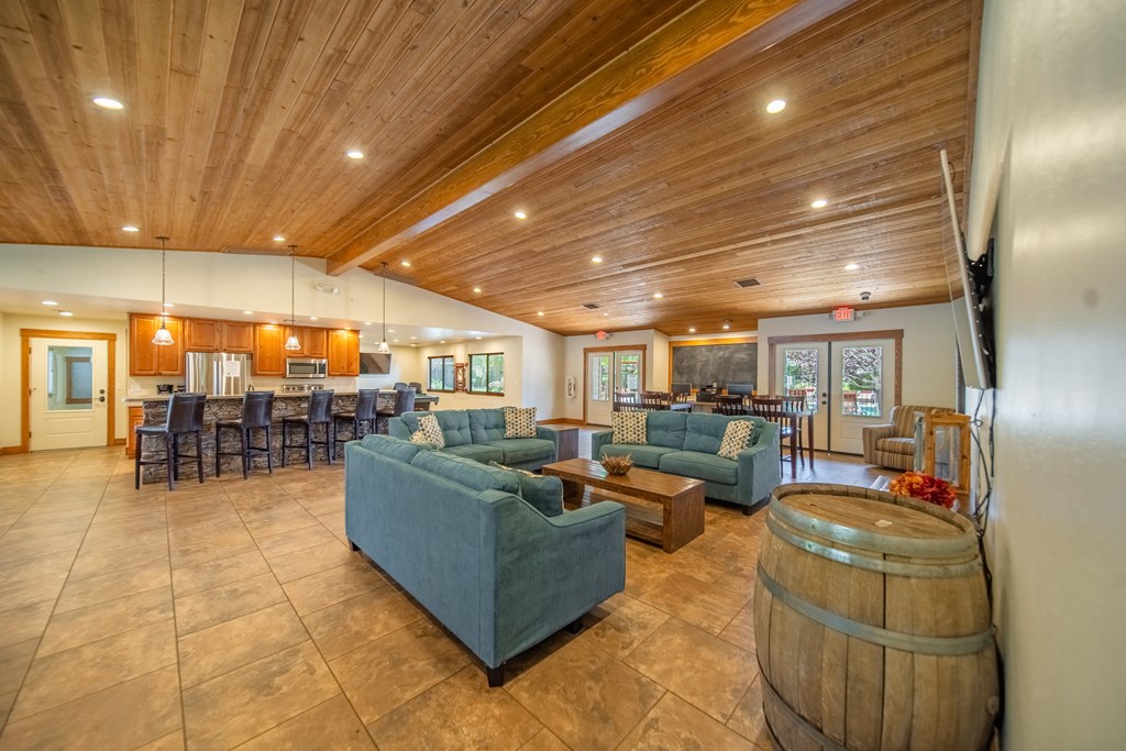 A large room with a wooden ceiling and a wine barrel.