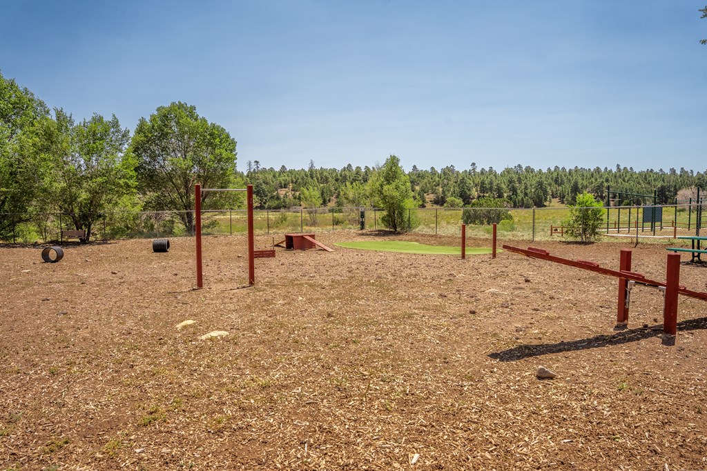 A field with red posts and a fence.