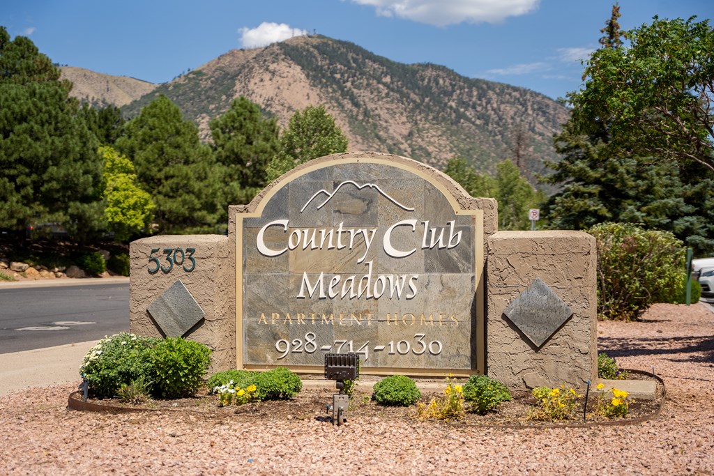 A sign for Country Club Meadows with a phone number on it.