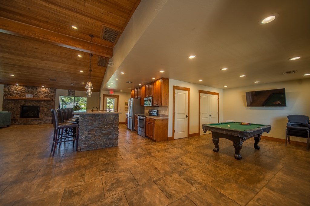 A room with a pool table and a fireplace.