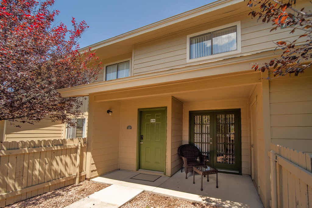 A house with a green door and a white fence.