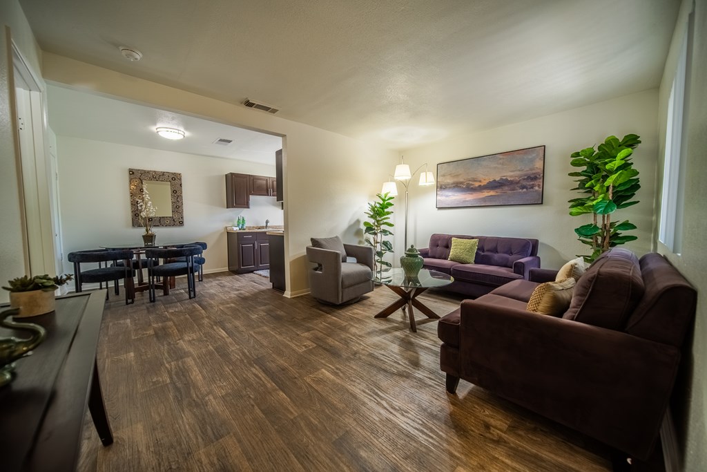 A living room with a brown couch and a wooden floor.