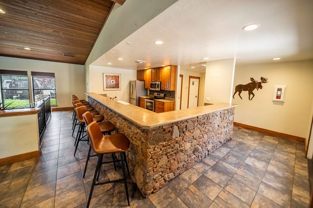 A bar area with a stone counter and chairs.
