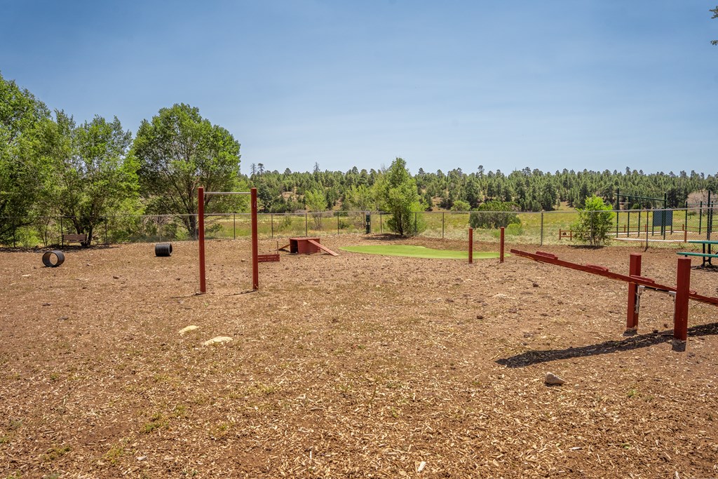 A field with red posts and a fence.