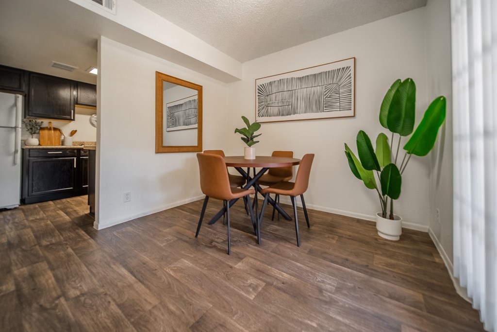 A dining room with a wooden table and chairs.