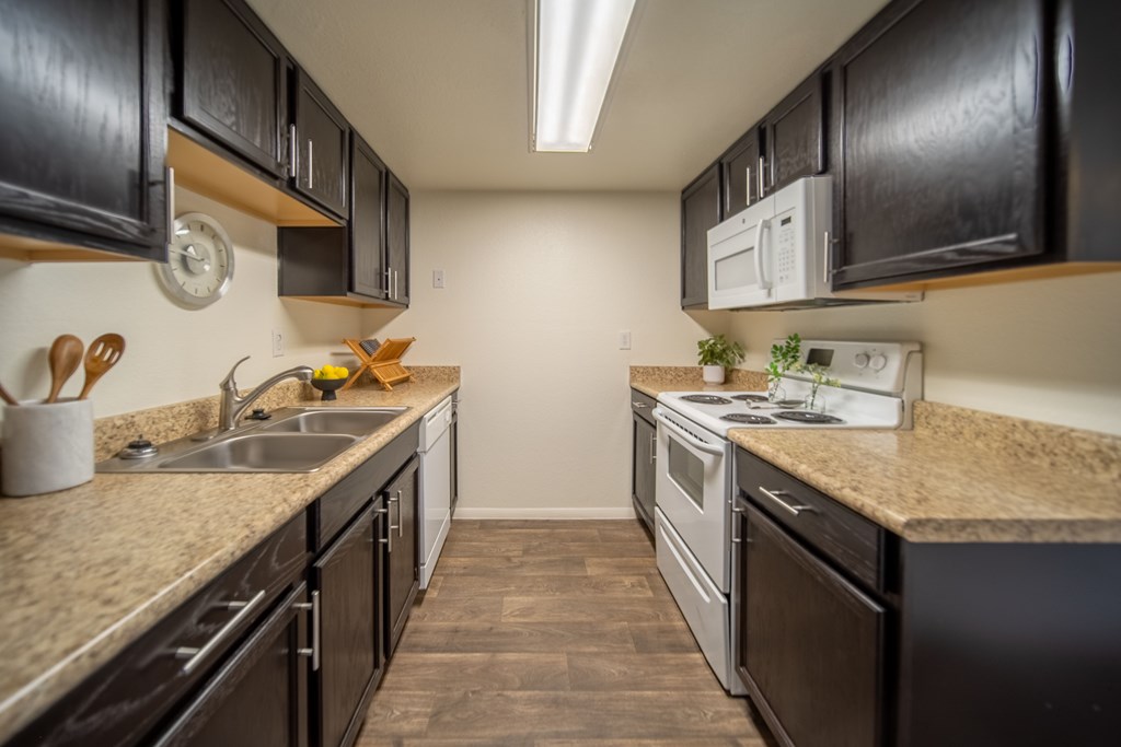 A kitchen with black cabinets and a white microwave.