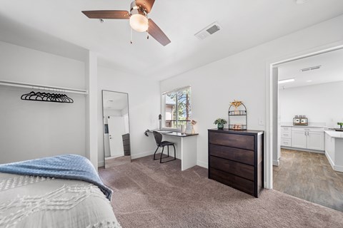 A bedroom with a bed, desk, and chair.