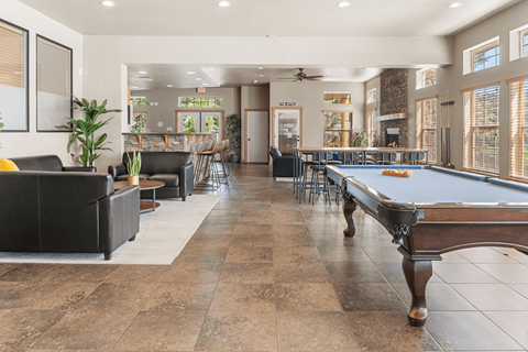 A large room with a pool table and a billiard table.