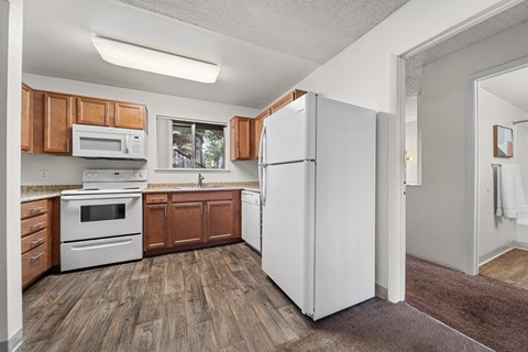 A kitchen with wooden cabinets and a white refrigerator.