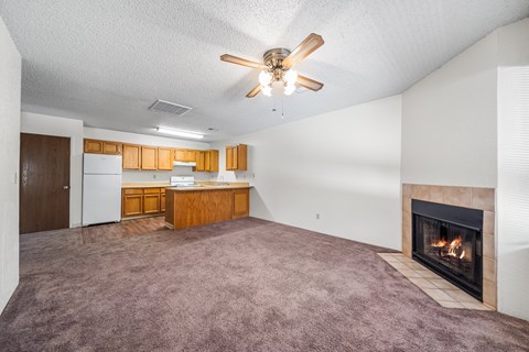 A living room with a fireplace and a ceiling fan.