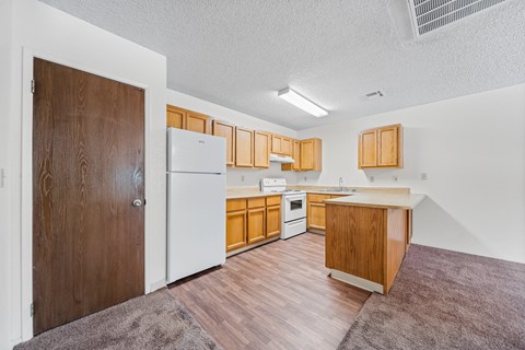 A kitchen with wooden cabinets and a white fridge.