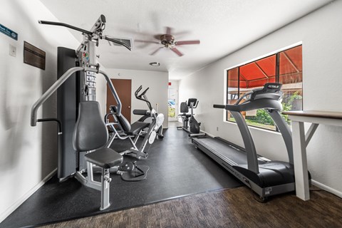 A fitness center with a treadmill, elliptical trainer, and stationary bike.