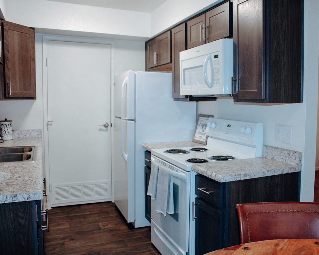 a kitchen with a white refrigerator freezer next to a stove top oven