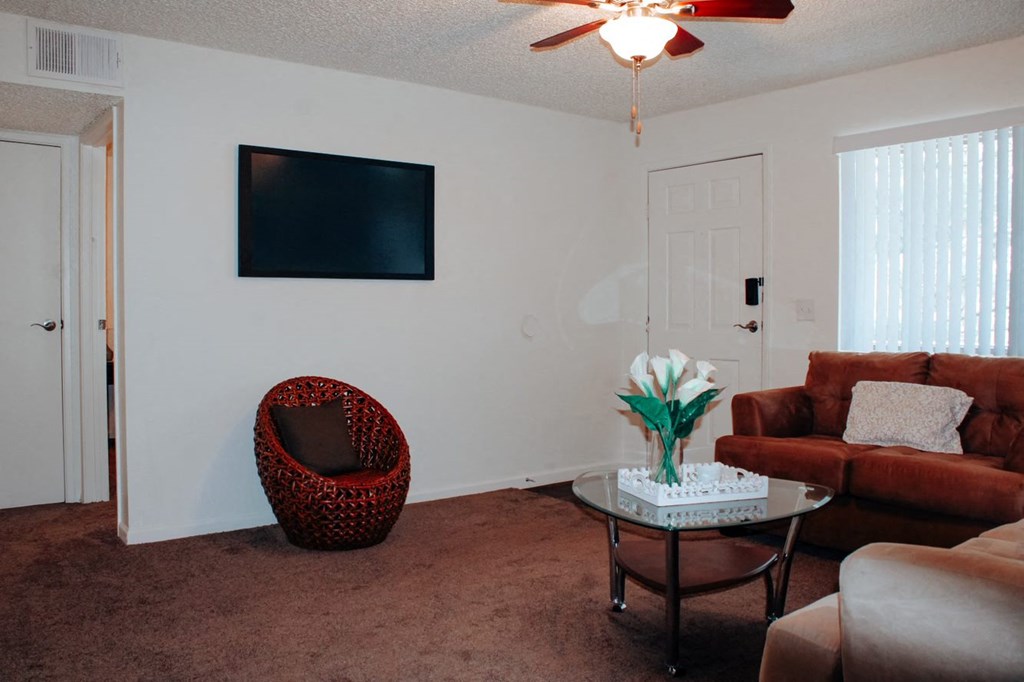 a living room with white walls and a brown carpet