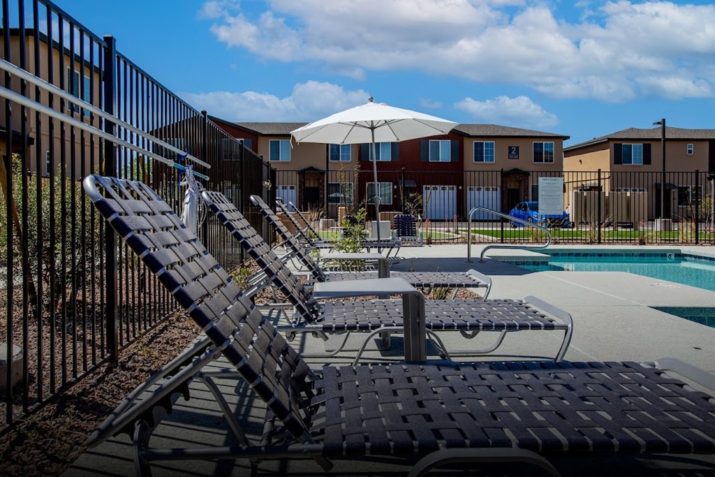 our apartments have a large pool with lounge chairs and an umbrella