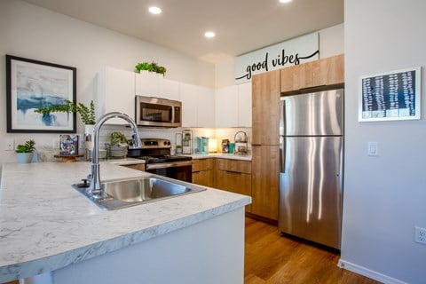 a kitchen with a sink and a stainless steel refrigerator