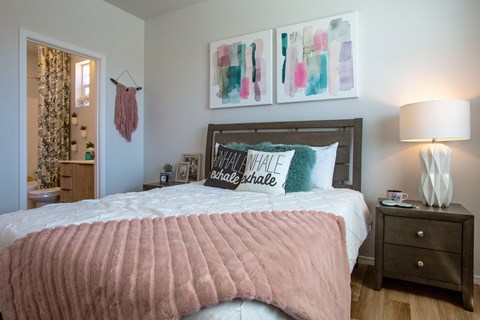 a bedroom with a bed and pictures on the wall