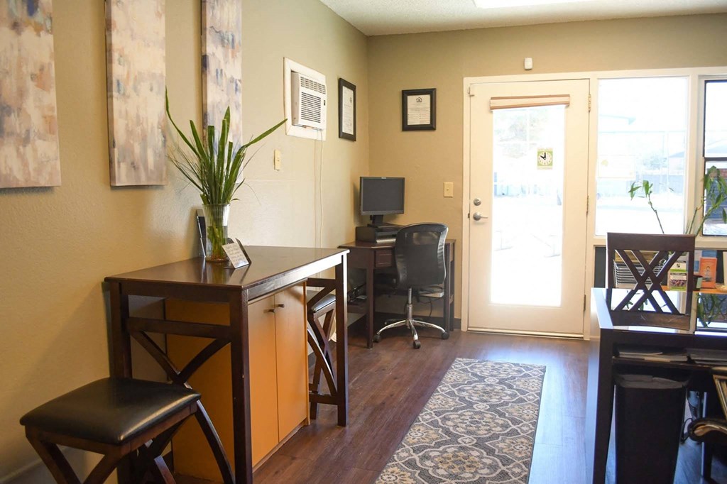 a room with a desk and chairs and a door that opens to a patio