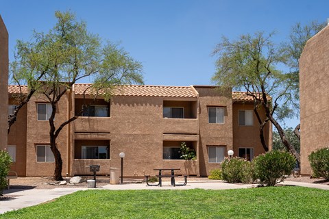 A building with a brown facade and a green lawn in front.