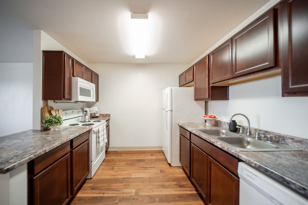 A kitchen with brown cabinets and a white refrigerator.