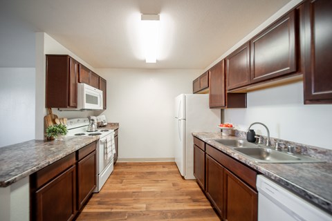 A kitchen with brown cabinets and a white refrigerator.