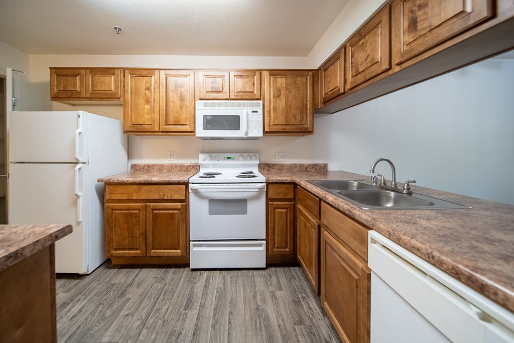 A kitchen with wooden cabinets and a white refrigerator.