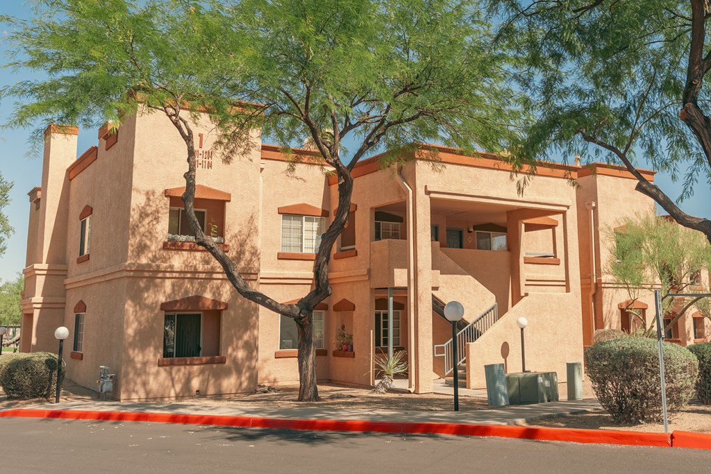 A building with a red roof and a tree in front of it.