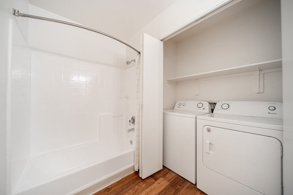 A white bathroom with a washer and dryer.