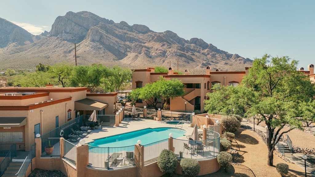 A resort with a pool and a mountain in the background.
