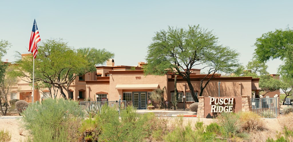 A building with a sign that says "Pusch Ridge" in front of it.