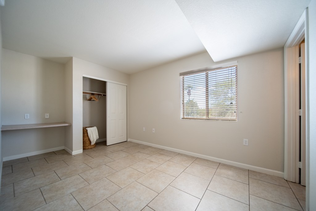 A room with a window and a closet.