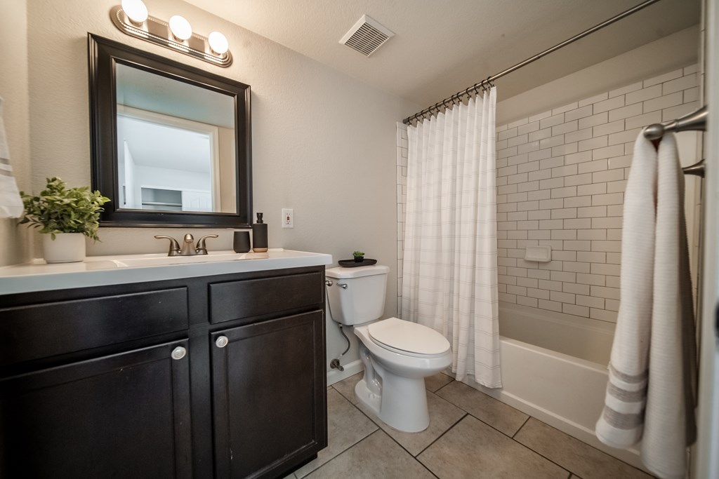 A bathroom with a toilet, sink, and shower.