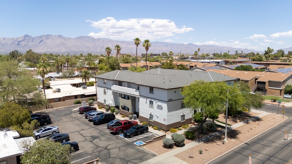 A parking lot with cars and a building in the background.