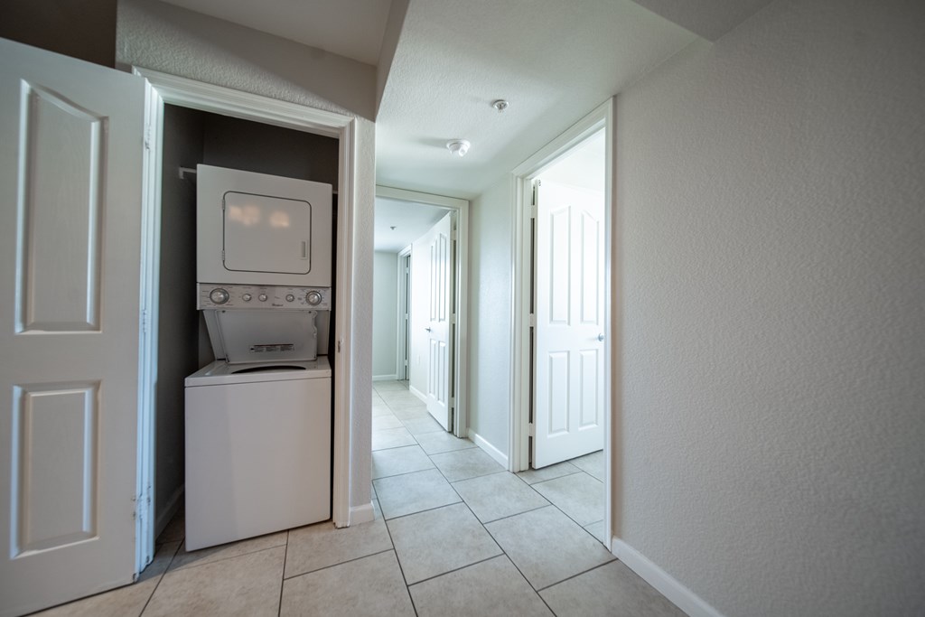 A white washing machine is in a small closet.